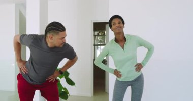 Egzersiz çağrısına yanıt olarak, çeşitli arkadaşlar modern ev yoga minderlerine hamleler yaparak ısınıyorlar. Fitness, dinamik, esneme, sağlık, aktivite, ev, modern