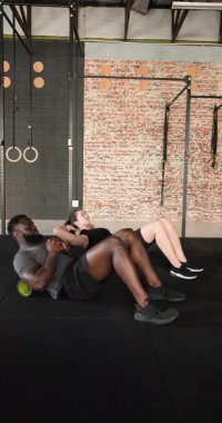 Dikey video: Omurga hareketi için yuvarlanan köpük silindirler ve spor salonunda kalçaları kaldıran çeşitli çiftler. Fitness, rehabilitasyon, esneklik, güç, sağlık, egzersiz, dikey video