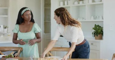 Çeşitli bayan arkadaşlar salata atıyorlar ekmek dilimliyorlar tereyağı sürüyorlar eve şarap döküyorlar. Sosyal, keyifli, kırsal, yaşam tarzı, boş zaman, topluluk, sıcaklık