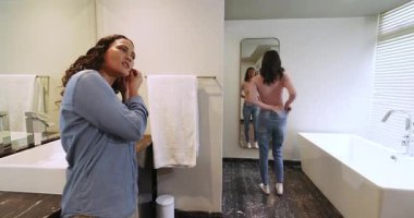 Bayan arkadaşlar, modern ev banyosunda mermer lavabo ile kıyafet hazırlıyor ve bot çekiyorlar. Lüks, zarafet, modernlik, yaşam tarzı, iç mekan, arkadaşlık, gelişigüzel