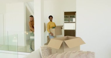 Çeşitli çiftler yeni oturma odasına yerleşiyor, kutuları açıyor, battaniye örtüyor ve kahveyi paylaşıyorlar. İç mekan, modern, yaşam tarzı, rahat, minimalist, yenileme