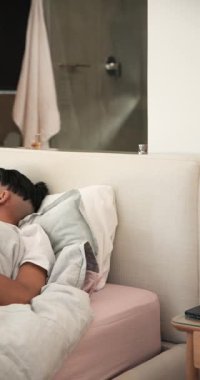 Yatak odasındaki çeşitli erkekler gülümseyip akıllı telefonu tutarken partnerleri de esneyerek tablet paylaşıyor. Samimiyet, rahatlama, bağlantı, konfor, modern yaşam tarzı, dikey video