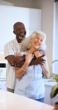 Farklı kıdemli çiftler pencereyi gösterdikten sonra mutfak adasında birbirlerine sarılıyorlar. Romantizm, arkadaşlık, samimiyet, rahat, modern, yaşam tarzı, dikey video