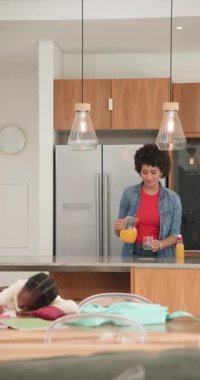 Anne ve kızı, portakal suyu getirerek, dizüstü bilgisayarda yazarak ve çalışma kitabı yazarak rutinlerini paylaşıyorlar. Aile, yetiştirme, iletişim, aile içi, günlük, gündelik, dikey video