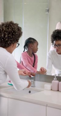 Çeşitli anne-kız uygulamaları macun fırçalama dişleri durulama ve lavaboda beşlik çakma. Aile, hijyen, bağlılık, bakım, aile içi, yaşam tarzı, dikey video