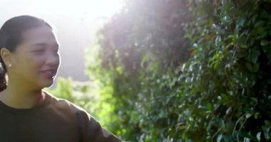 Çerçeveye giren Asyalı kadın, çitin yanında yürüyen bahçe yolu, kozalaklı iğneler, kopyalama alanı. Botanik, sükunet, doğal, dinginlik, manzara, refah, açık hava