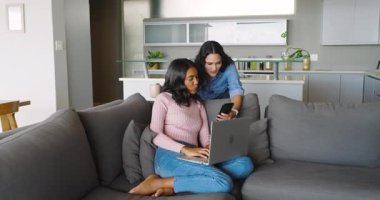 Oturma odasındaki kanepede oturan pembe kazaklı kadın dizüstü bilgisayar kullanıyor, fotokopi çekiyor. Modern, ev, iç mekan, rahat, çalışma alanı, minimalist