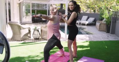 Yüzük ışığı etkinleştiriyor, Afrikalı Amerikalı eğitmen Beyaz Kadın Savaşçı II havuz başında poz veriyor. Spor, sağlık, açık hava, öğretici, farkındalık, sağlık, egzersiz