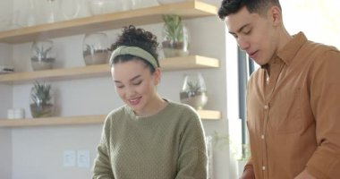 Gülümseyen ve konuşan bir çift mutfak adasında servis için sebze dilimliyor. Aile, işbirliği, sağlıklı yaşam, aşçılık, yaşam tarzı, modern tasarım, tazelik