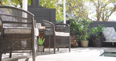 Güvertedeki hasır koltukların üzerinde dönen kamera sobayı geçince havuz başı şezlongları, fotokopi alanı. Açık hava, rahatlama, kırsal alan, peyzaj, boş zaman, ortam, konforlu