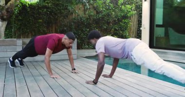 Farklı erkek arkadaşlar nefes verdikten sonra güvertede el sıkışarak ve ileri doğru yürürken şınav çekiyorlar. Fitness, yoldaşlık, açık hava, zindelik, güç, takım çalışması, refah