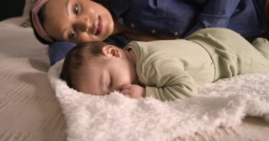 Kamera, annenin yatakta uyuyan kızını gözlemlediğini gösteriyor. Sakin bir bağ kurduğunu gösteriyor. Samimiyet, huzur, şefkat, aile içi, samimi, sevgi dolu, huzur dolu.