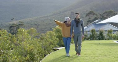 Benekli tepe, farklı çim kenarlarında yürüyen çift el ele tutuşuyor, kollarını kıvırıyor ve manzarayı paylaşıyor. Romantik, doğa, macera, yürüyüş, manzara, arkadaşlık, sükunet