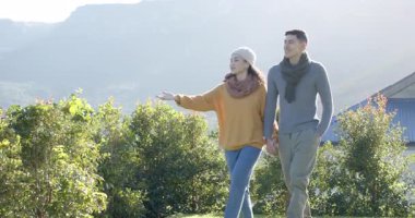 Güneşli bahçeye adım atan Asyalı çift tepe noktalarını gösteren çitler boyunca el ele yürüyorlar. Romantik, doğa, açık hava, manzara, sükunet, keşif, arkadaşlık.