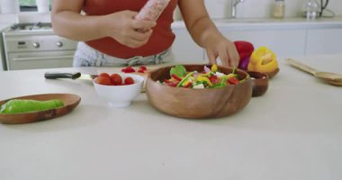 Tuz öğütücü Asyalı kadın mutfakta salata, biber öğütme, zeytinyağı serpiştirme. Aşçılık, aşçılık, yemek hazırlama, modern mutfak, taze malzemeler, sağlık yaşam tarzı, yaşam tarzı.