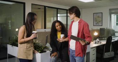 Bilgilendirme için tablet tıklamalar, çeşitli takımlar ofis bölmesine yaslanarak kahve ile slaytları aşırıyorlar. İşbirliği, takım çalışması, modern, profesyonel, iletişim, başlangıç, teknoloji