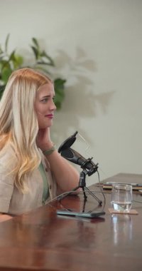 Dikey video: Stüdyoda podcast bölümü için iki kadın sunucu mikrofona konuşuyorlar. Podcast, iletişim, işbirliği, sohbet, stüdyo, beyin fırtınası, dikey video