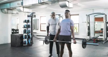 Afrika kökenli Amerikalı erkek stajyer antrenör, kauçuk zeminde el çırparak yol gösteriyor. Spor, spor, spor, spor, motivasyon, kas gücü.