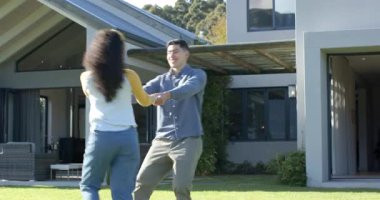 Ön bahçede el ele tutuşan, kucaklaşan, şakacı dans eden bir çift. Romantizm, açık hava, mutluluk, yaşam tarzı, eğlence, kutlama, doğal