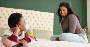 Çeşitli bayan arkadaşlar, uzaktan kumandayla arkadaşını eğlendirmek için hikaye anlatırken gülüyorlar. Arkadaşlık, arkadaşlık, bağlantı, neşe, eğlence, gündelik, samimi