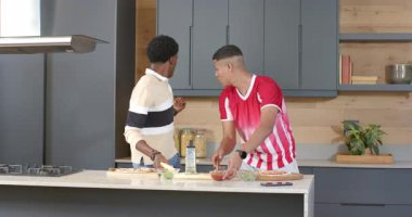 Açlıktan kaynaklanan çeşitli arkadaşlar peynir serpme, soslama ve mutfak adasında baharat öğütme. Aşçılık, aşçılık, hazırlık, modern, yaşam tarzı, takım çalışması, canlı