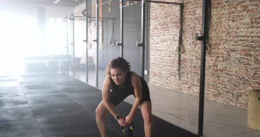 Beden eğitimi için kettlebell 'i sıkıca kavrayan sporcu, kalça menteşesinden göğse doğru sallanıyor. Zindelik, kuvvet, hareket, dayanıklılık, sağlık, kararlılık, dinamik