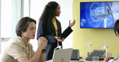 Türbin ve güneş modelleri aracılığıyla temiz enerji sunan çeşitli iş arkadaşları başlangıç noktasında toplantı odasında. Yenilik, sürdürülebilirlik, işbirliği, teknoloji, profesyonellik, çevre dostu, takım çalışması