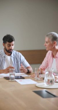 Çeşitli iş arkadaşları atıcının yanına notlar yazarak dosyaları yerleştiriyor ve tartışmak için dizüstü bilgisayara güç veriyor. İşbirliği, takım çalışması, profesyonel, tartışma, konferans, beyin fırtınası, dikey video