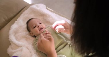 Anne ve kız, oturma odasındaki lüks battaniyede oynamak için el ele tutuşuyorlar. Ninni, beslenme, gülümseme, etkileşim, yumuşaklık, rahatlık, çocukluk.