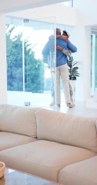 Dikey video: Afrika kökenli Amerikalı aile sırt çantasıyla dönen asker olarak evlerinin kapısında sarılıyor. Birleşme, aile, duygusal, sıcak, destekleyici, çağdaş, dikey video