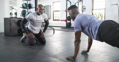 Afro-Amerikalı stajyer şınav çekiyor, örümceklere beşlik çakıyor. Eğitim, fitness, power, atletizm, motivasyon, takım çalışması, egzersiz