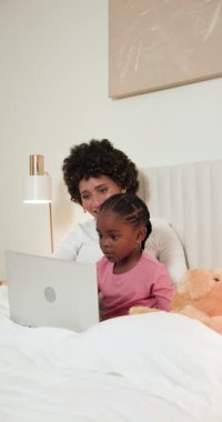 Çeşitli anne ve kızlar laptopun yatakta dinlendiğini fark ediyor. Öğrenmek ve gülümsemek için daktilo yazıyor. Aile, akıl hocalığı, bağlantı, beslenme, rahatlık, eğitim, dikey video