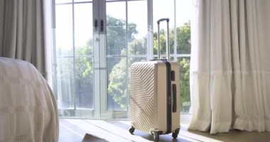 Oyunda, bej rengi dönen bavul 360 derece dönüyor. Kamera yatak odasını göstermek için geri çekiliyor. Seyahat takımları, bavullar, modern iç dekorasyon, stresten arınmış seyahat, tekstil, minimalist stil.