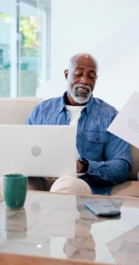 Dikey video: Afro-Amerikan asker oğlu kağıtları uzatıyor, babası kanepeye dizüstü bilgisayarla bakıyor. Aile, akıl hocalığı, takım çalışması, iletişim, modern, gündelik, dikey video