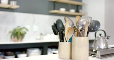 Başlangıçta, kamera sabit duruyor ve mutfak rafları ve çatal bıçak tutacaklarına odaklanıyor. Minimalist, modern, iç mekan, yemek takımı, tasarım, yaşam tarzı, çağdaş