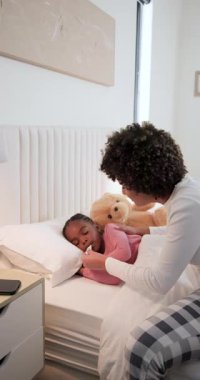 Afrika kökenli Amerikalı anne ve kız termometreyi yerleştiriyor, hemşireyi telefonla arıyor, fotokopi çekiyor. Bakım, sağlık, konfor, beslenme, evcil, duygusal, dikey video