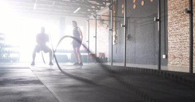 Çeşitli antrenman partnerleri halatları sıkıyor dalgaları başlatıyor, güç için spor salonunda çömeliyor, kopyalama alanı yaratıyor. Fitness, dayanıklılık eğitimi, takım çalışması, enerji, canlılık, kapalı spor salonu, aktif yaşam tarzı