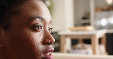 Sesi duyan, gülümseyen, gülen ve suratını ekşiten Afrikalı Amerikalı bir kadın. Portre, duygu, rahatlama, iç mekan, canlı, konuşma, yaşam tarzı