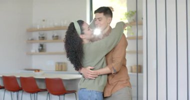 İspanyol çift, erkeğin kadının ellerine ulaşması ve mutfak tezgahının etrafında dönmesi üzerine dans ediyor. Romantizm, samimiyet, dans, bağlantı, modern, samimi, mutluluk