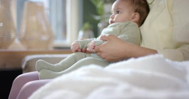 Anne ve bebek kanepede tekme atarken ayaklarını ritimli bir şekilde indiriyorlar. Aile, sevgi, bağlılık, kreş, şefkat, neşe, samimiyet