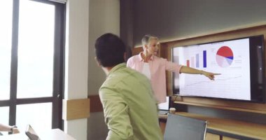 Çeşitli iş arkadaşları toplantı odasına girip müşteri eğilimlerini açıklayan çizelgeler üzerinde işbirliği yapıyorlar. İş, takım çalışması, sunum, modern, veri, profesyonel, iletişim