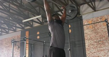 Göğüs halterini kavradıktan sonra Afrika kökenli Amerikalı bir adam başınızın üstüne bastırıp spor salonunda çömeldi. Güç, fitness, egzersiz, antrenman, atletik, motivasyon, egzersiz