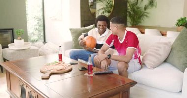 Farklı erkek arkadaşlar kanepede oturmuş tezahürat yapıyor ve pizza yiyorlar. Günlük, dostluk, eğlence, kutlama, kentsel, canlı, boş zaman