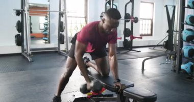 Spor salonuna gelen adam, dambılları sırayla kaldırıyor, ter siliyor, bir sonraki setten önce duraksıyor. Güç, fitness, egzersiz, antrenman, atletik, kararlılık, spor