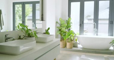 Kayıtta, kamera banyoda bitkileri, lavaboları, küveti ve duşu gösteriyor. Minimalist, lüks, doğal, spa, zarif, sakin, çağdaş