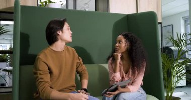 Çeşitli iş arkadaşları ofise girip tablet üzerindeki işleri gözden geçiriyorlar ve kahve kupalarını yudumluyorlar. İşbirliği, iletişim, takım çalışması, modern, gündelik, profesyonel, tartışma