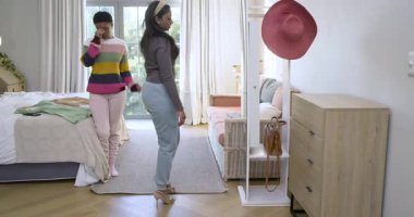 Çeşitli bayan arkadaşlar yatak odasına giriyor, yataktaki kıyafetleri değerlendiriyor, yeşil elbiseleri fotoğraflıyor. Arkadaşlık, moda, tarz, günlük, yaşam tarzı, iç mekan, ev