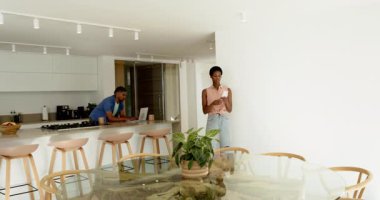 Erkek dizüstü bilgisayarla uğraşırken, kadın kumaş parçaları getiriyor, kartları yerleştiriyor ve boş duvar için boya seçiyor. Çağdaş, işbirliği, iç mekan, ev dekorasyonu, renk paleti, yenilik, minimalizm