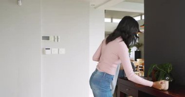 Paltolar ve çantalar, ev girişinde konsol masası, fincanlar ve bitkilerle bekleyen kadın arkadaşlar. Dostluk, konukseverlik, modern, yaşam tarzı, konforlu, günlük, iç mekan