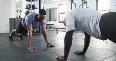 Afro-Amerikan koç ve koç stajyer jimnastik salonunda beşlikle şınav çekiyor. Fitness, strength, team work, motivasyon, eğitim, egzersiz, power